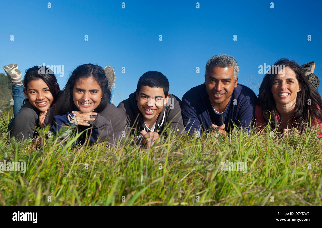 Hispanic family smiling in grass Stock Photo - Alamy
