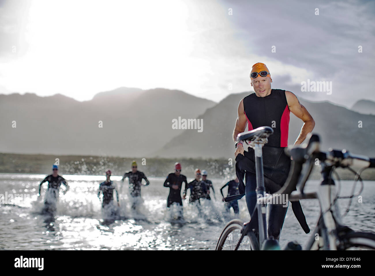 Triathletes emerging from water Stock Photo