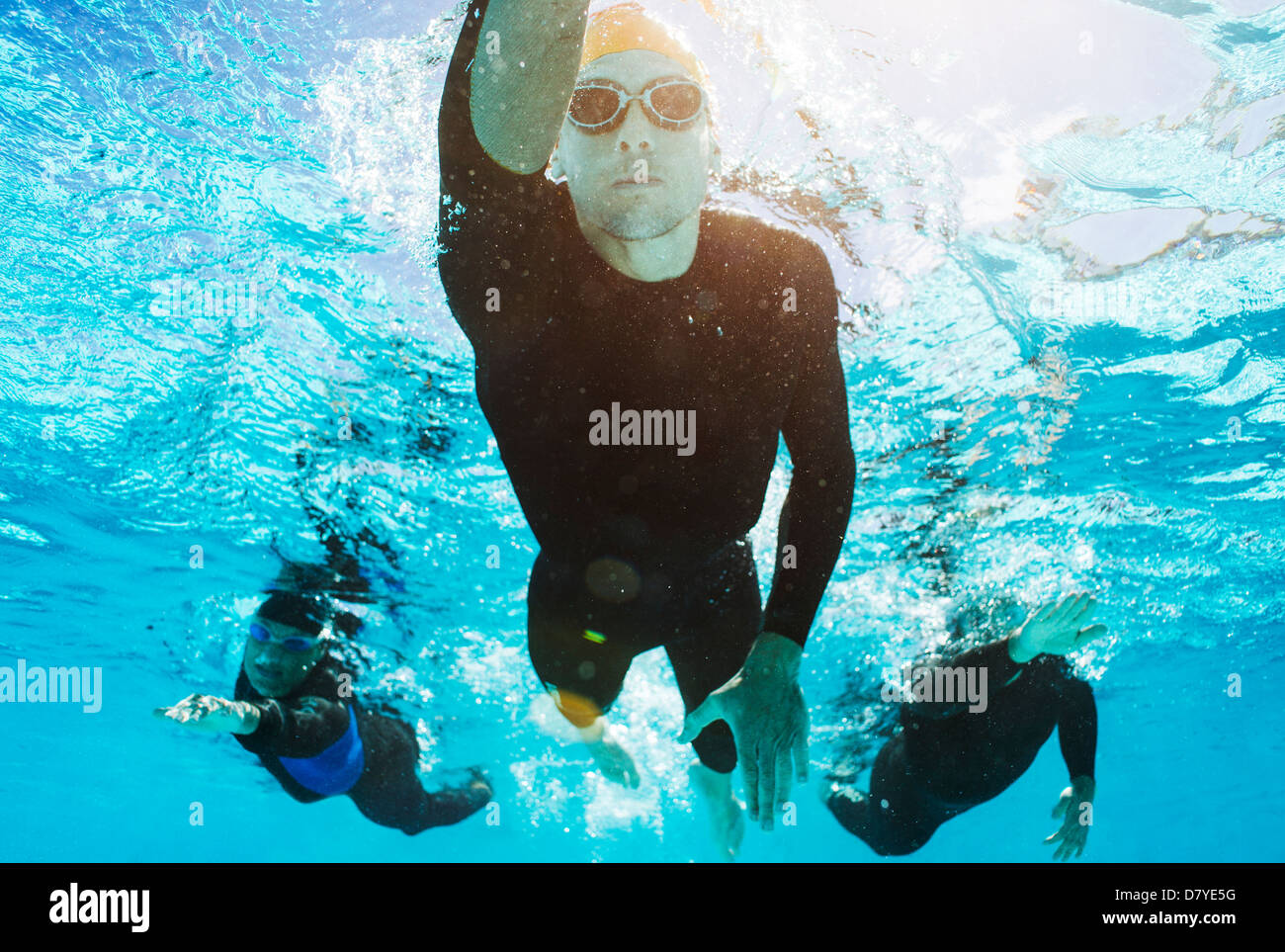 Triathletes in wetsuits underwater Stock Photo