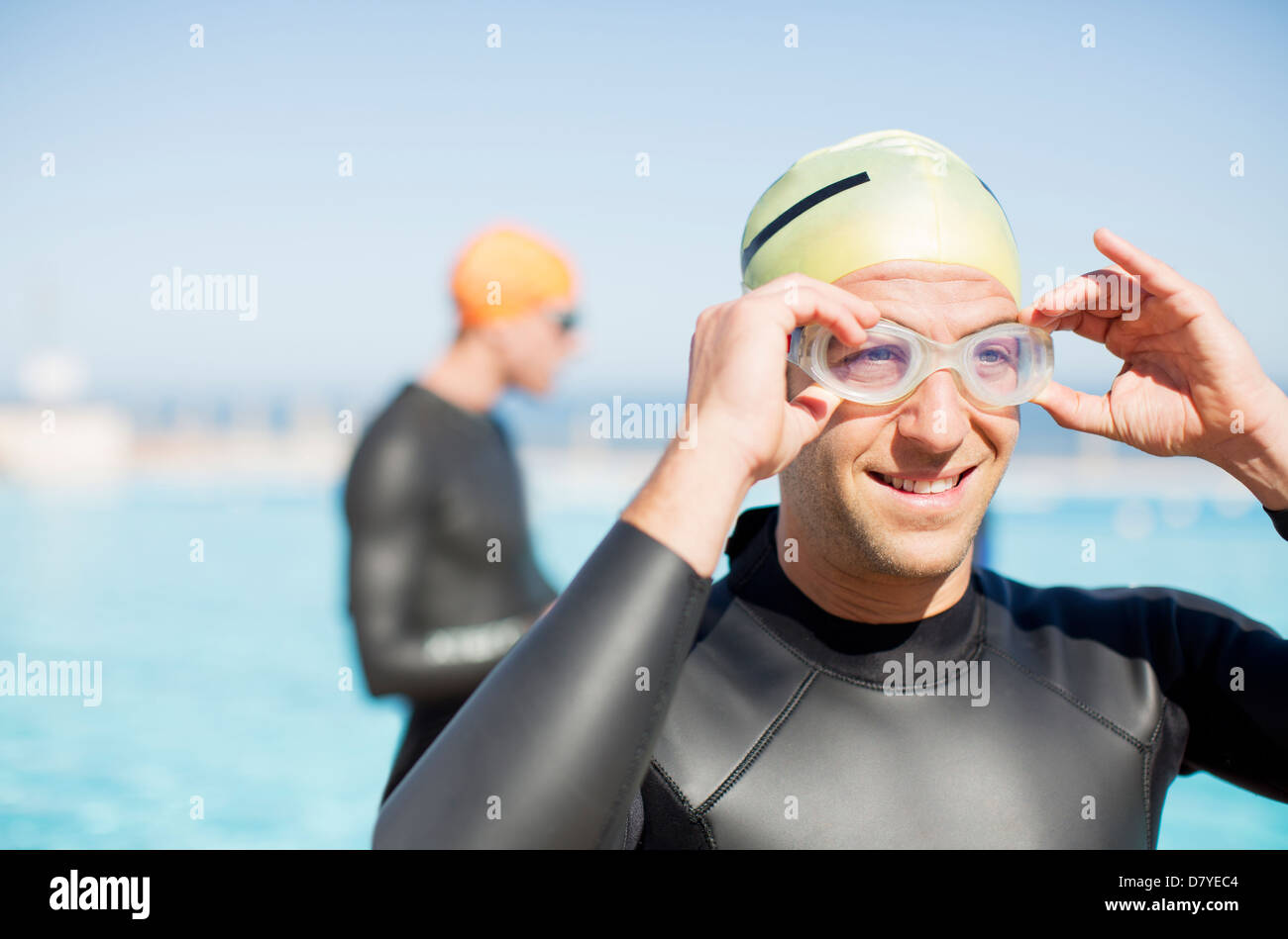 Triathlete adjusting goggles outdoors Stock Photo