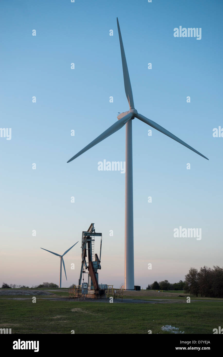Oil pump jack and wind turbines at sunset in central Oklahoma near