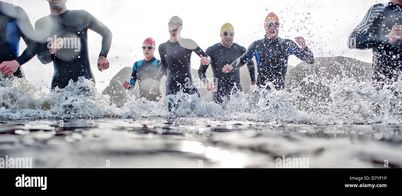 Triathletes emerging from water Stock Photo