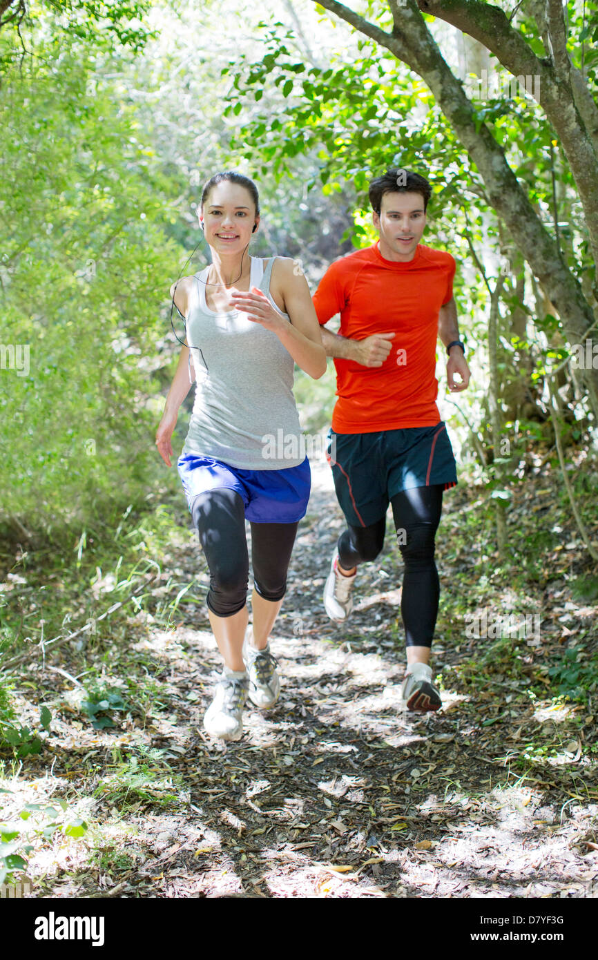 Couple running on dirt path Stock Photo