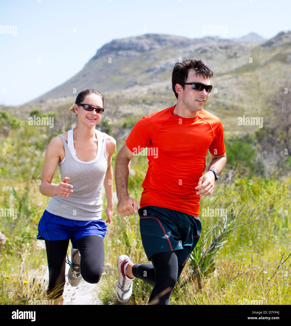 Couple running on dirt path Stock Photo