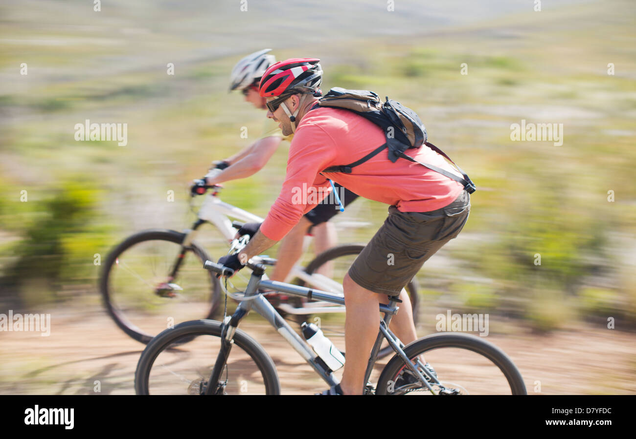 Blurred view of mountain bikers on dirt path Stock Photo
