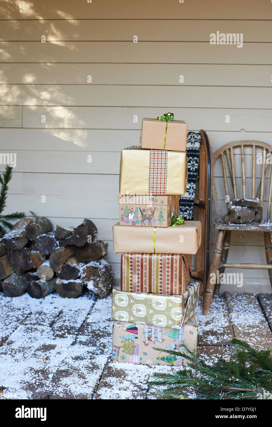 Stack of Christmas gifts on snowy patio Stock Photo - Alamy