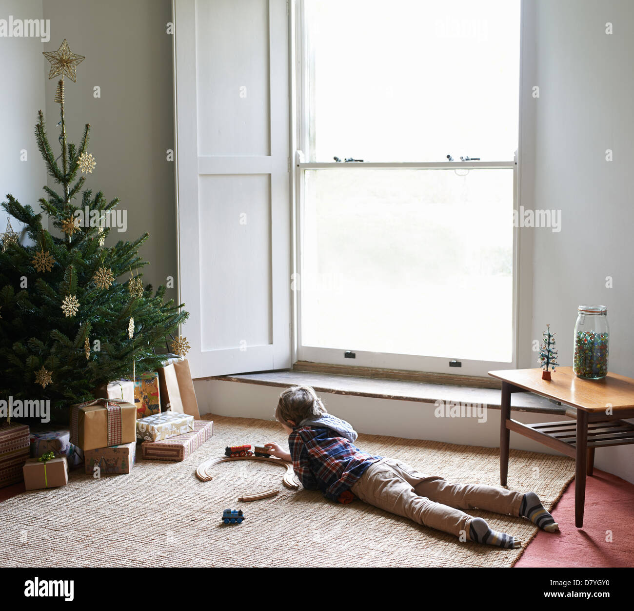 Boy playing with train by Christmas tree Stock Photo