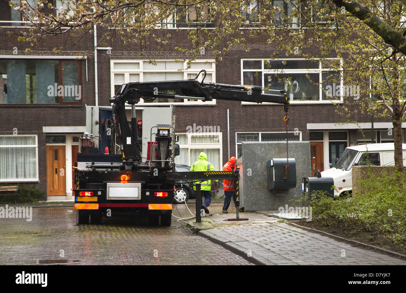 Repair of underground waste container in city street on rainy day Stock Photo