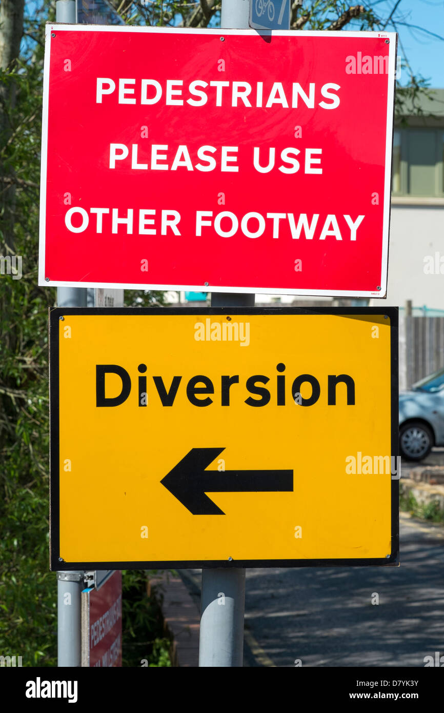 Red and yellow pedestrian footpath diversion signs Stock Photo Alamy