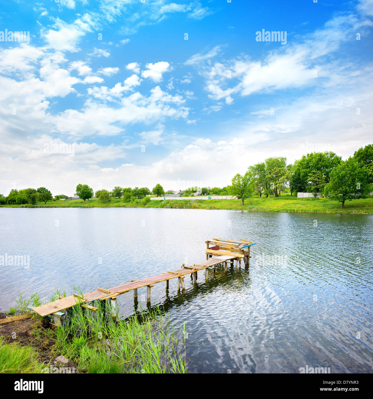 Wooden dock, pier, on a lake in summer sunny day Stock Photo
