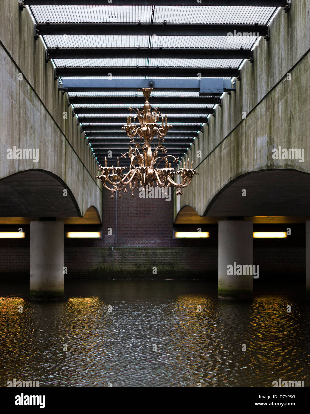 Shot of a golden chandelier hanging under a bridge above a river which makes an abstract looking image Stock Photo