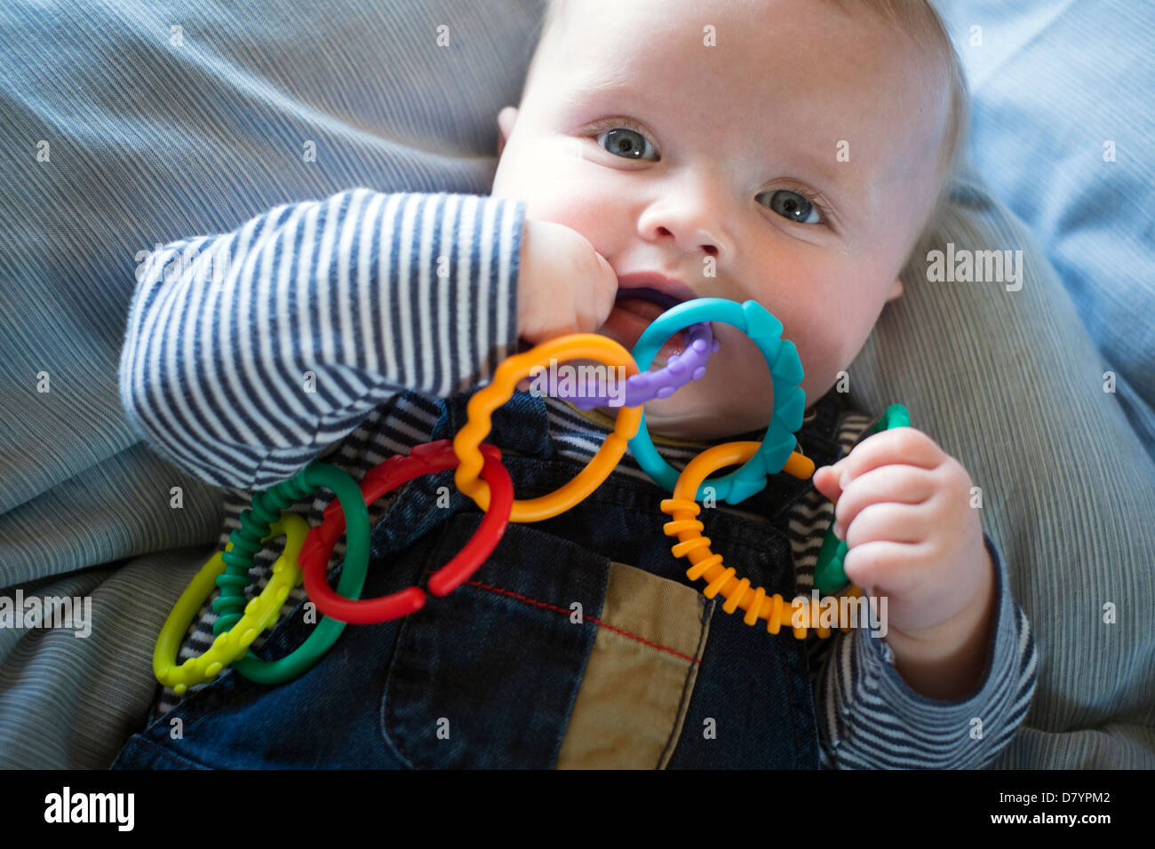 A baby boy playing with teething rings. Stock Photo