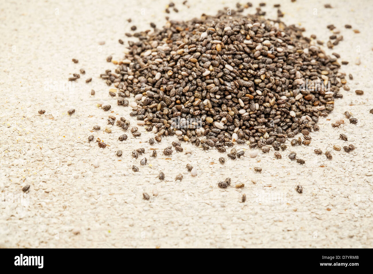 a pile of black chia seeds on a rough white painted barn wood