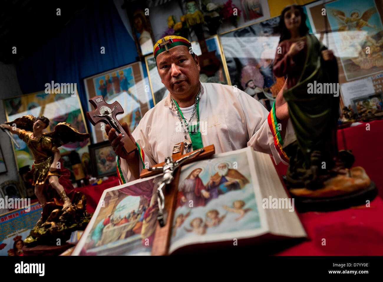 Hermes Cifuentes, a Colombian spiritual healer, prays at an altar in his apartment before performing a ritual of exorcism. Stock Photo