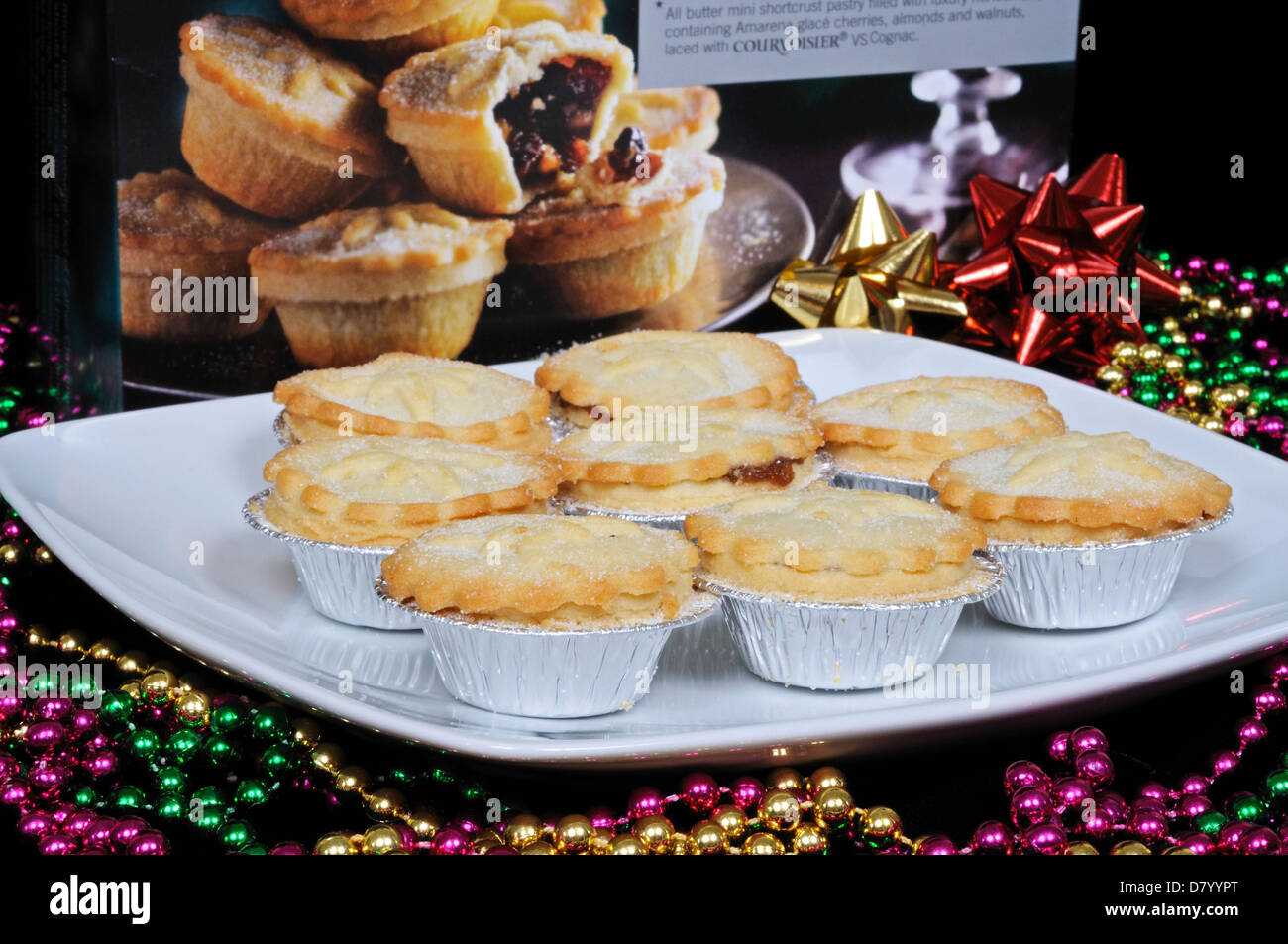 Mince pies on a white plate surrounded by colourful beads. Stock Photo