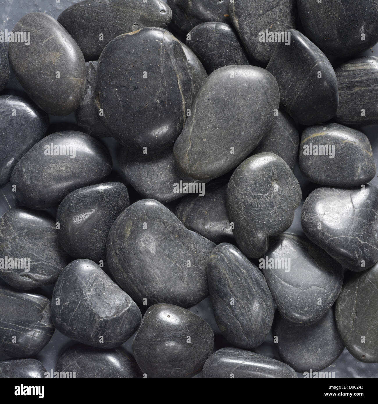 Shiny Black sea side pebbles Stock Photo