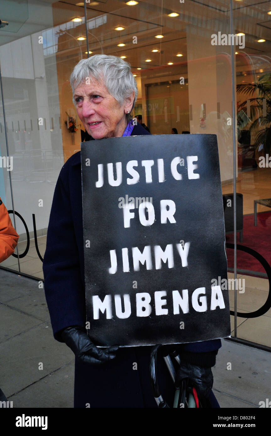A woman holds a black placard ' justice for Jimmy Mubenga' outside the headquarters of G4S. Stock Photo