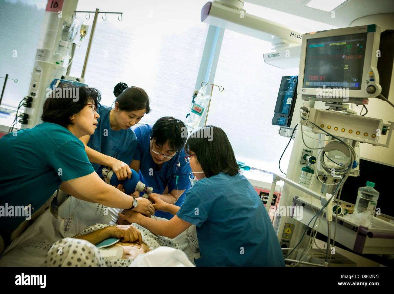 Medical staff use an oxygen tank to help revive the patient who is under anaesthetic in the intensive care unit. Stock Photo
