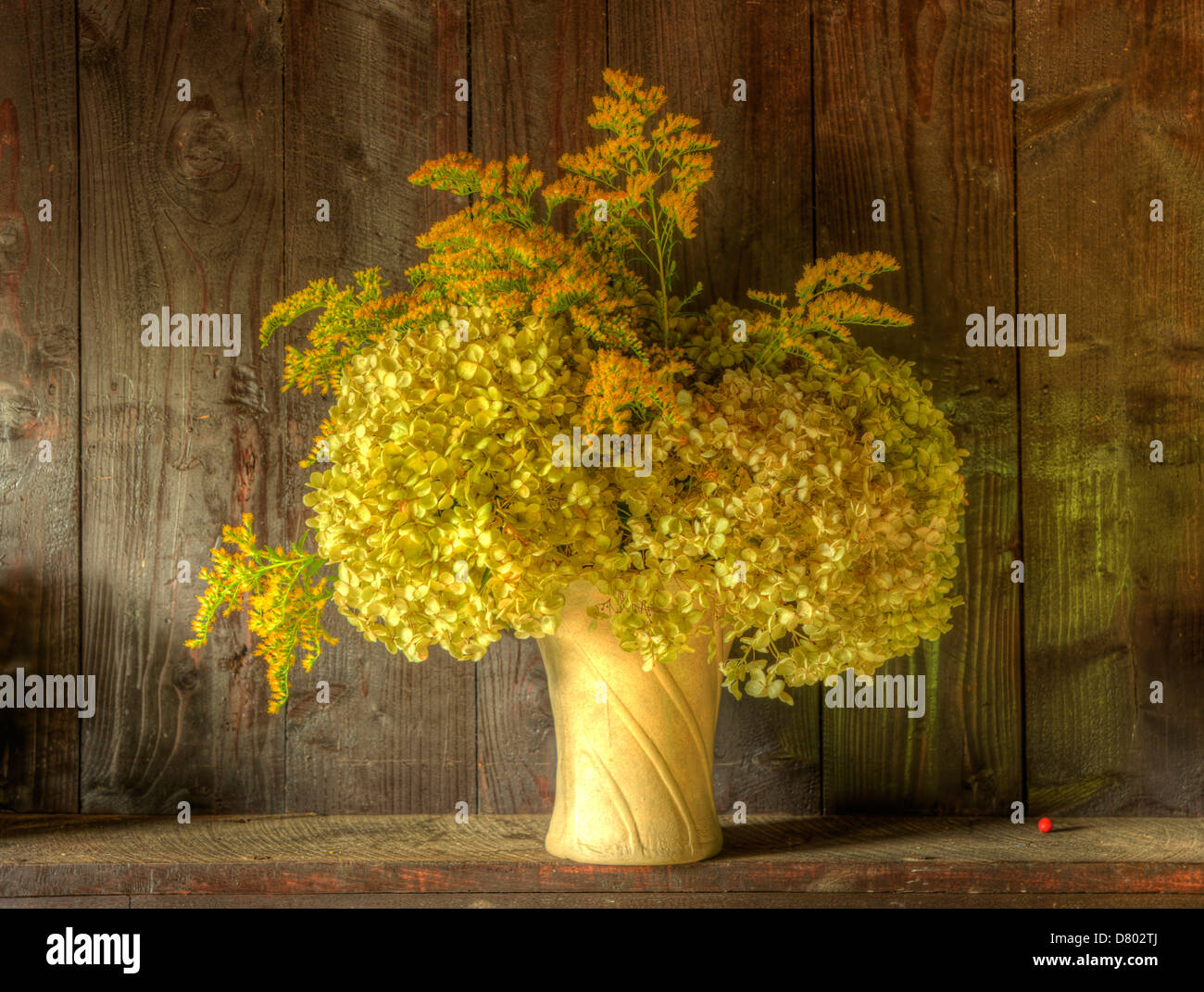 Still life image of dried flowers in rustic vase against weathered ...