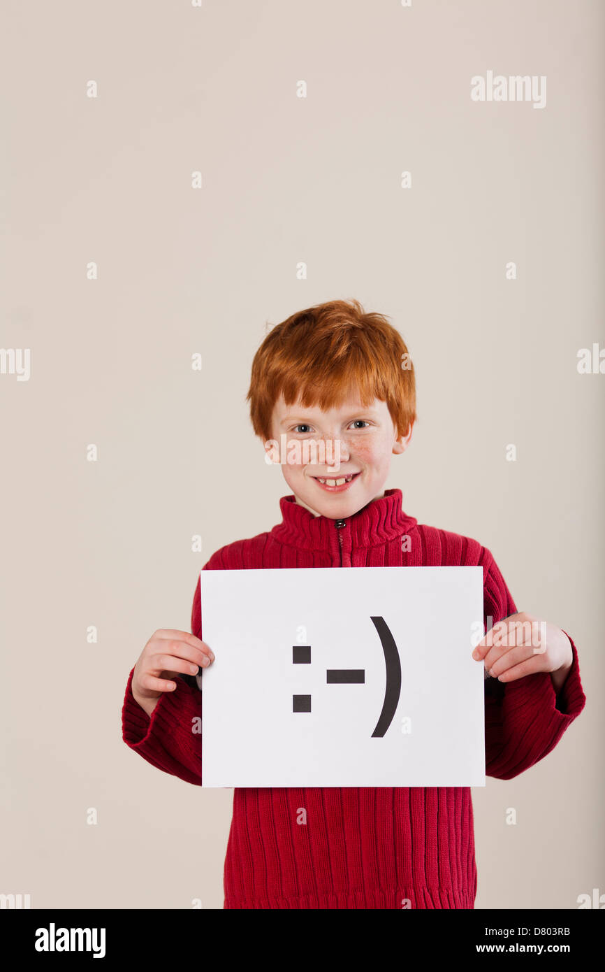 Caucasian boy holding card with smiley face Stock Photo