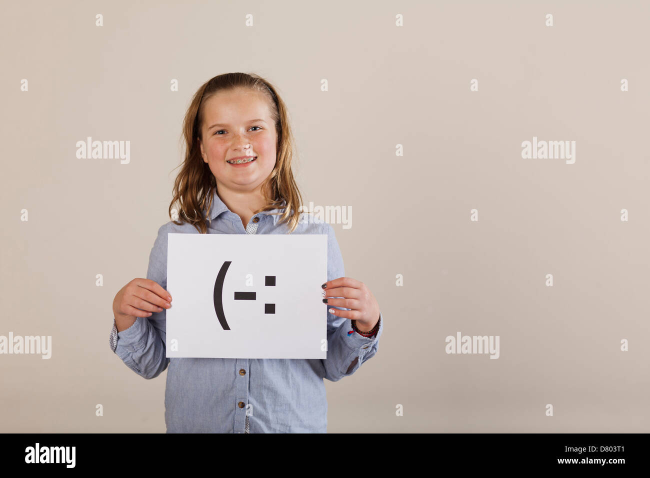 Caucasian girl holding card with smiley face Stock Photo