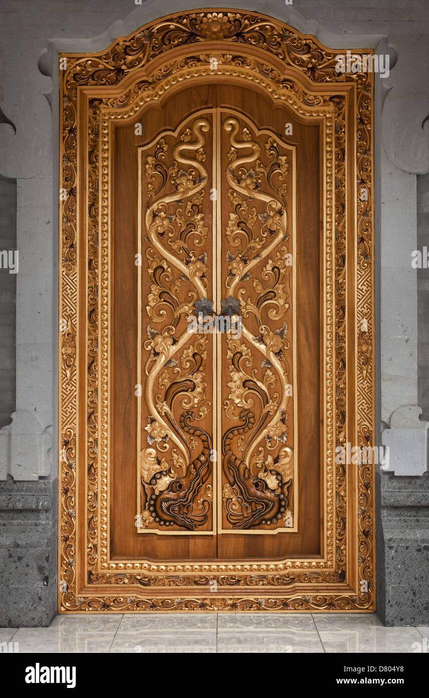 The wooden door of an old temple covered with carvings. Indonesia, Bali Stock Photo