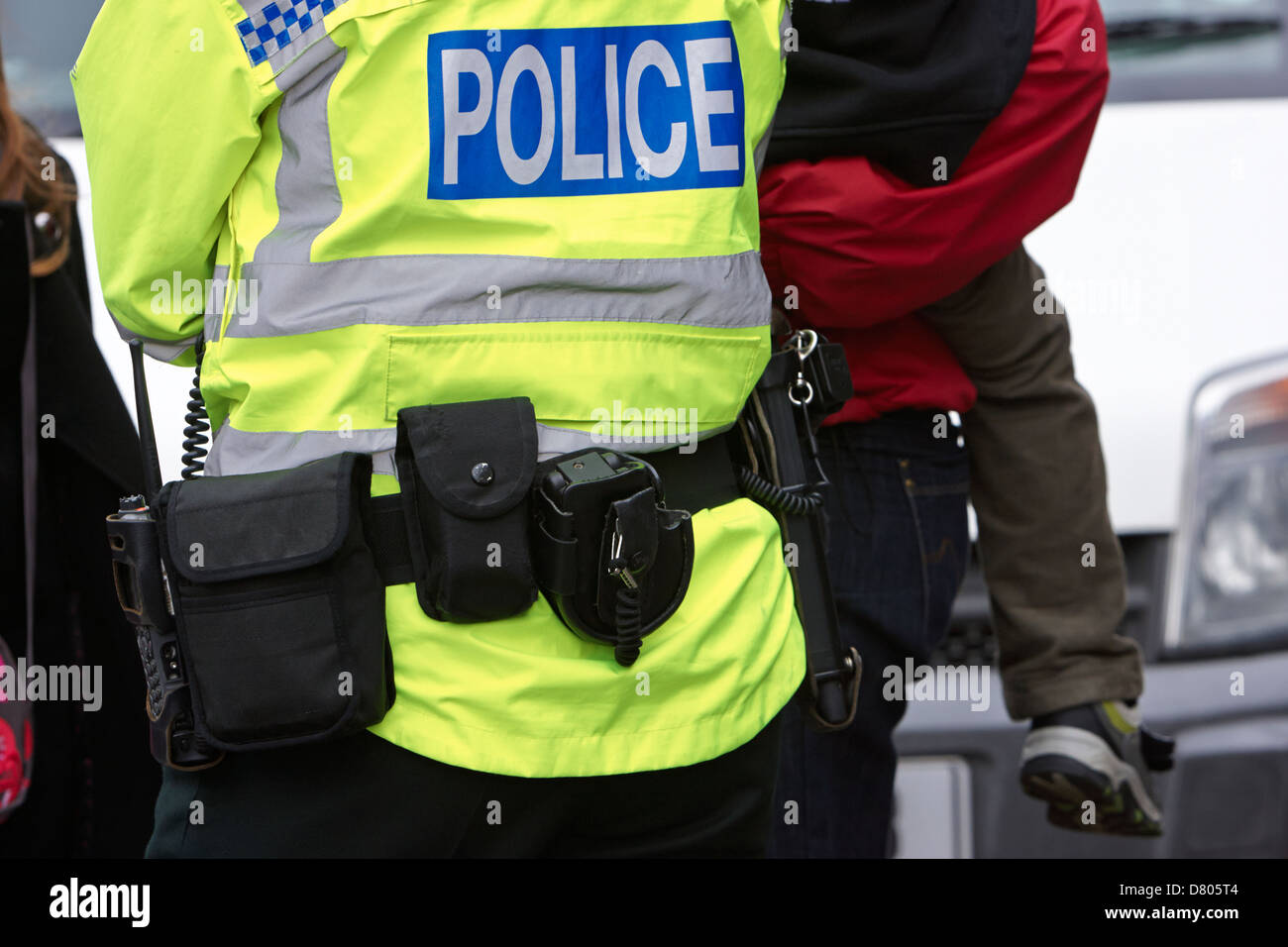 armed female police officer talking to mother carrying child at an outdoor event in the uk Stock Photo