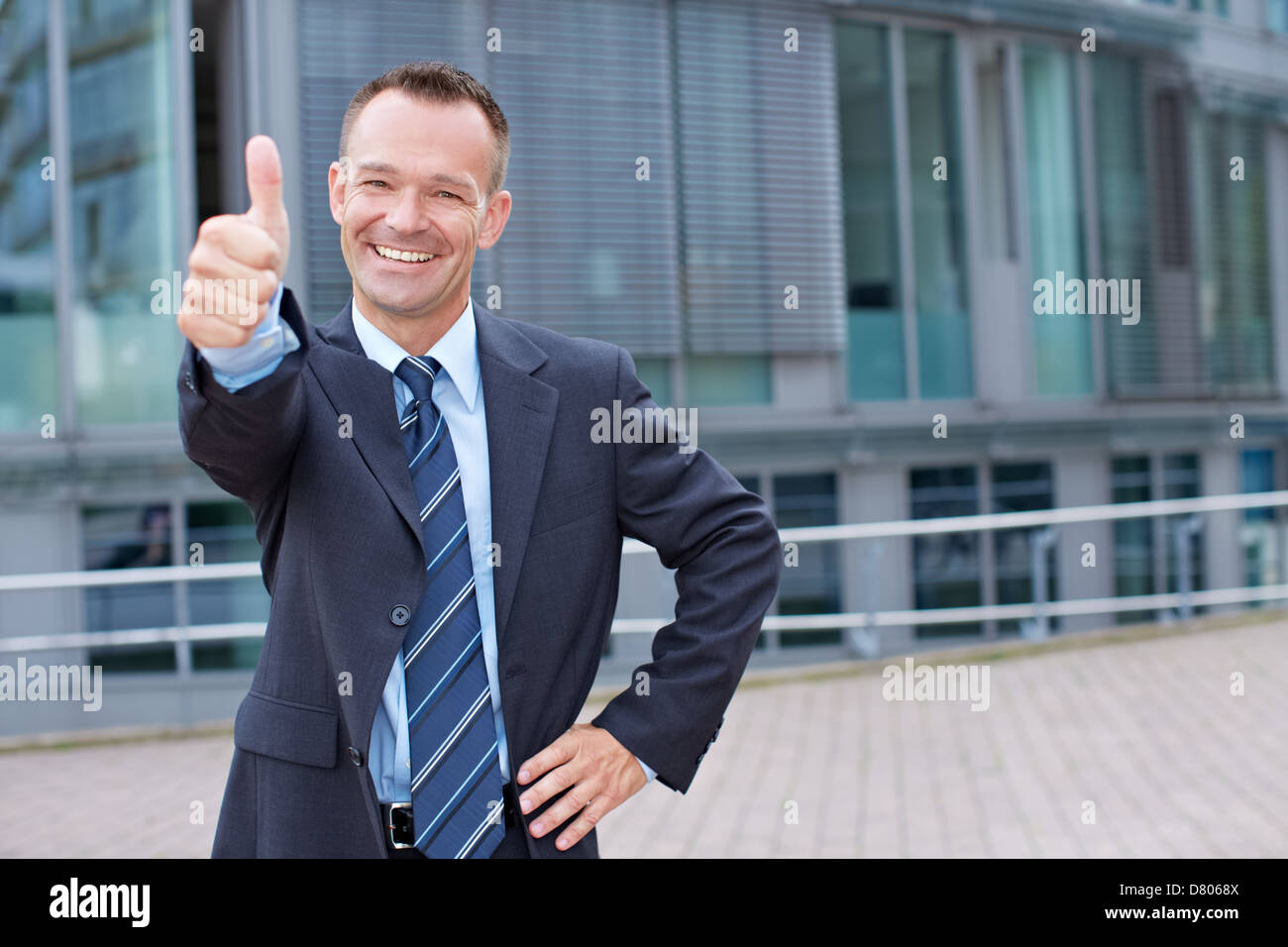 Happy business man outside holding his thumbs up Stock Photo