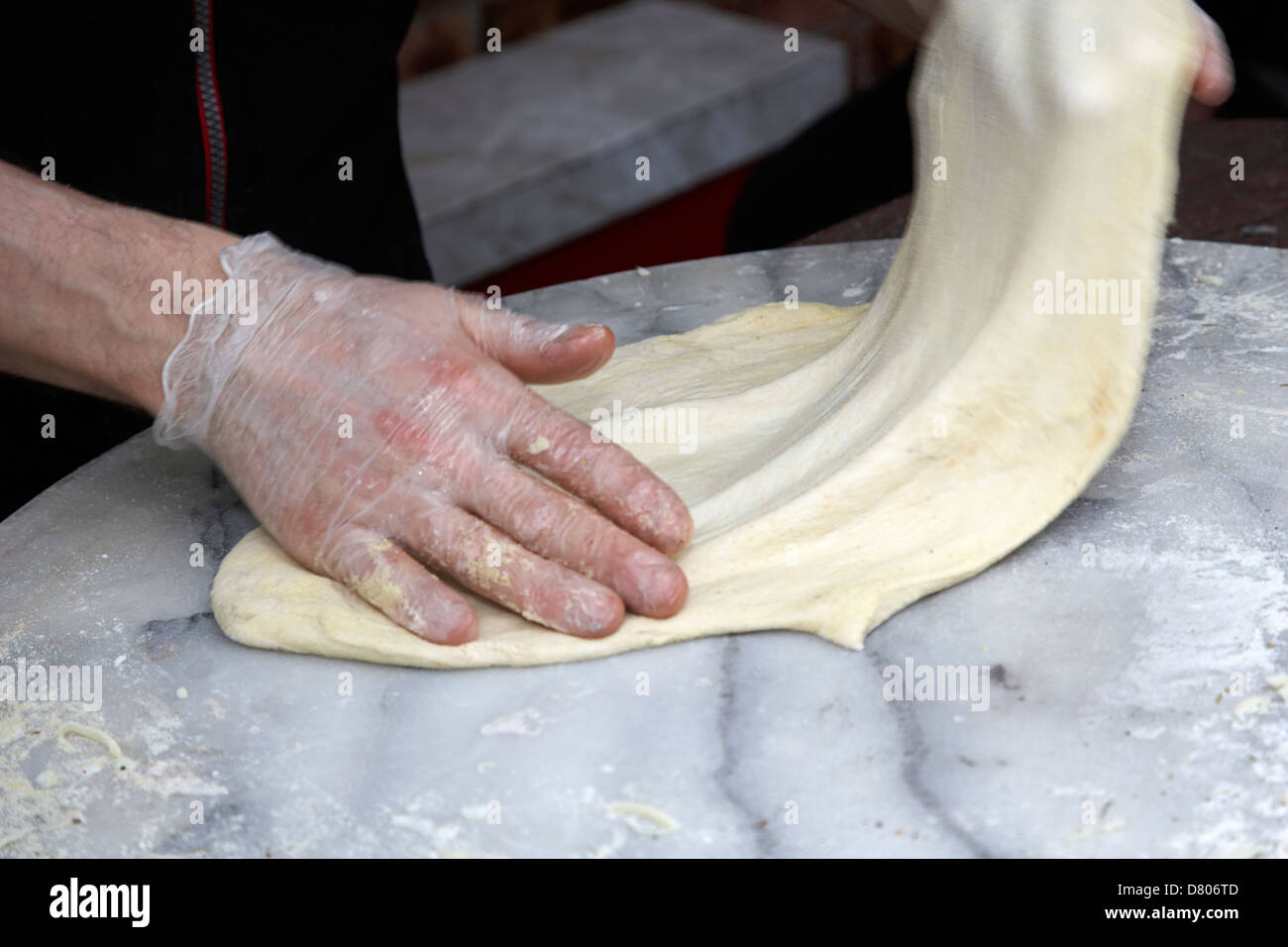 man making pizza stretching base dough deliberate motion blur Stock Photo