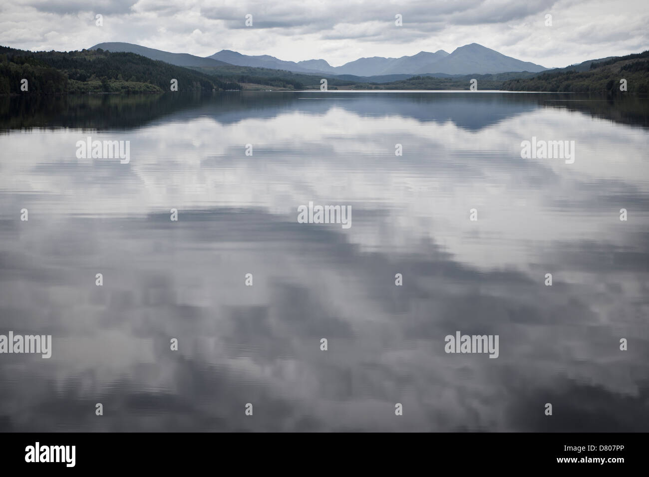 Cloudy sky reflected in still rural lake Stock Photo - Alamy