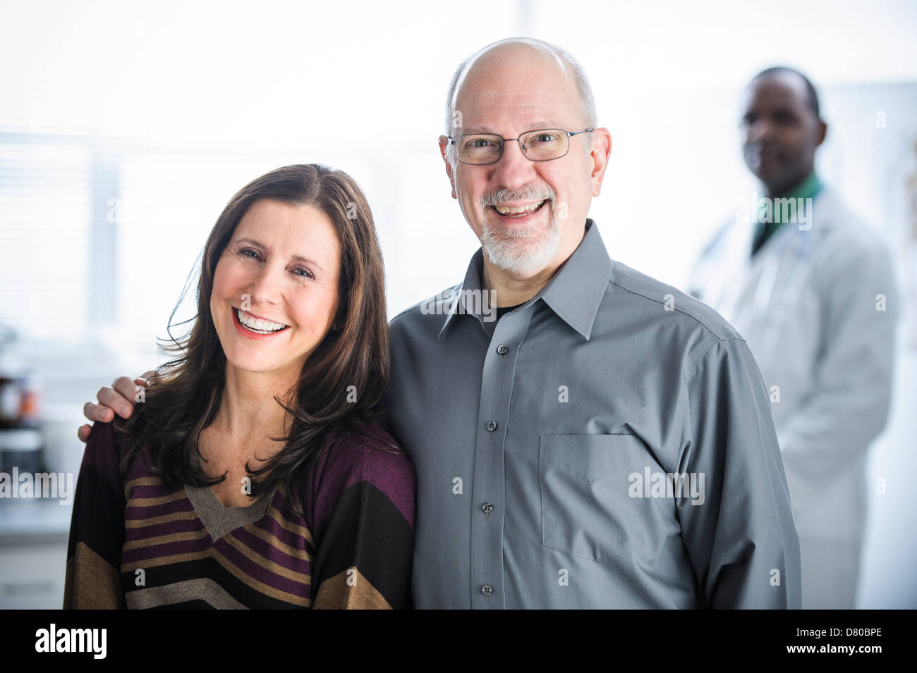 Smiling couple standing in doctor's office Stock Photo