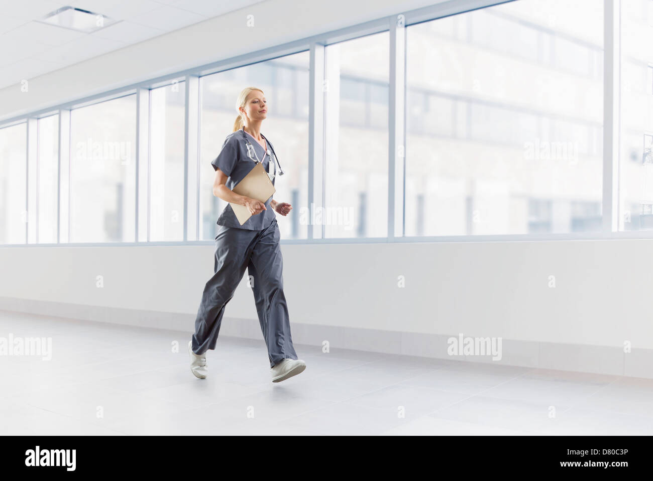 Caucasian nurse walking in hospital Stock Photo