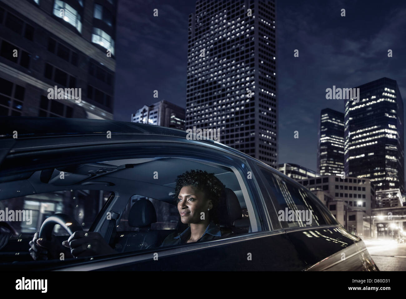 African American woman driving on city street Stock Photo