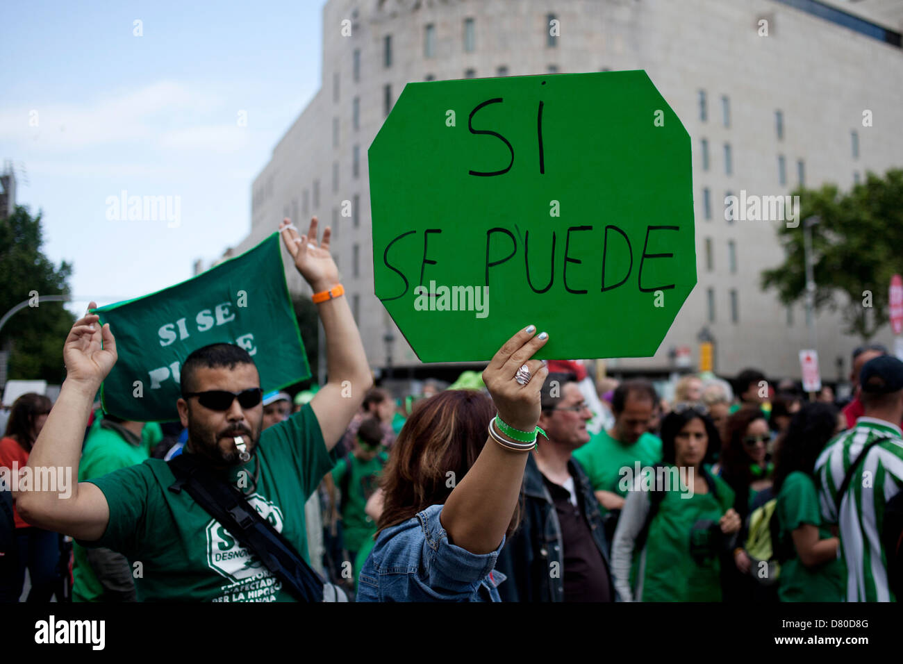 During a 12M demonstration, a women carries a poster when can read: Si se puede (Yes we can) Stock Photo