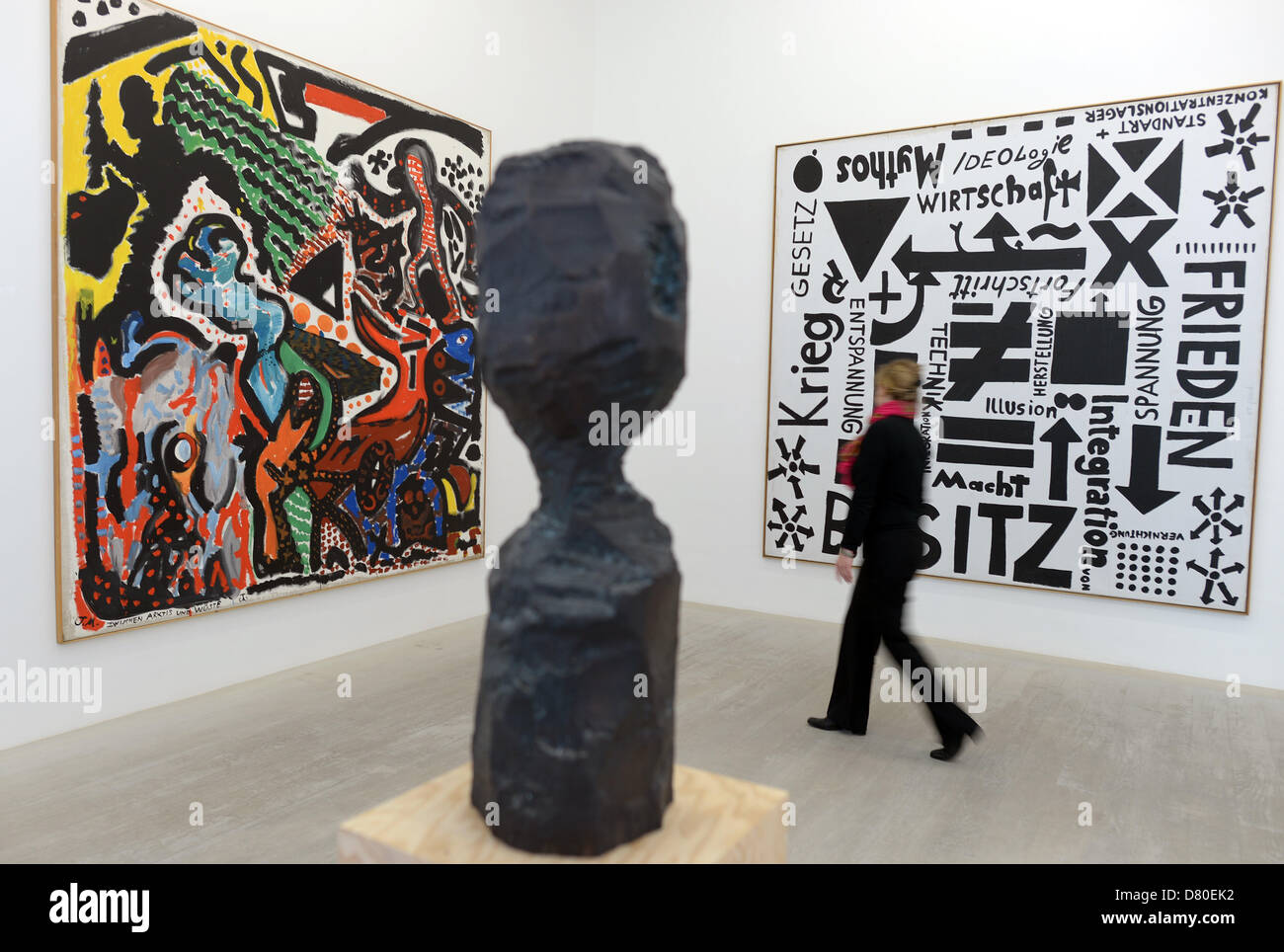 An employee of the academy gallery walks past 'Zwischen Arktis und Wueste' (1975), 'Flugblatt (Macht-Besitz)' (1974) and the sculpture 'Selbstkopf' (1984) at the Kunstakademie in Duesseldorf, Germany, 16 May 2013. The Kunstakademie is exhibiting a retrospective of the work of a former professor A. R. Penck from 17 May until 14 July. Photo: FEDERICO GAMBARINI Stock Photo