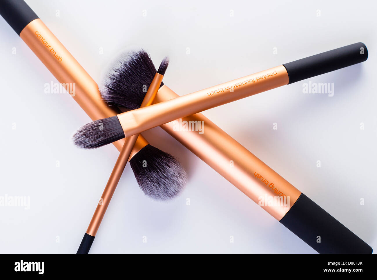 stack of four bronze makeup brushes in an abstract shape Stock Photo