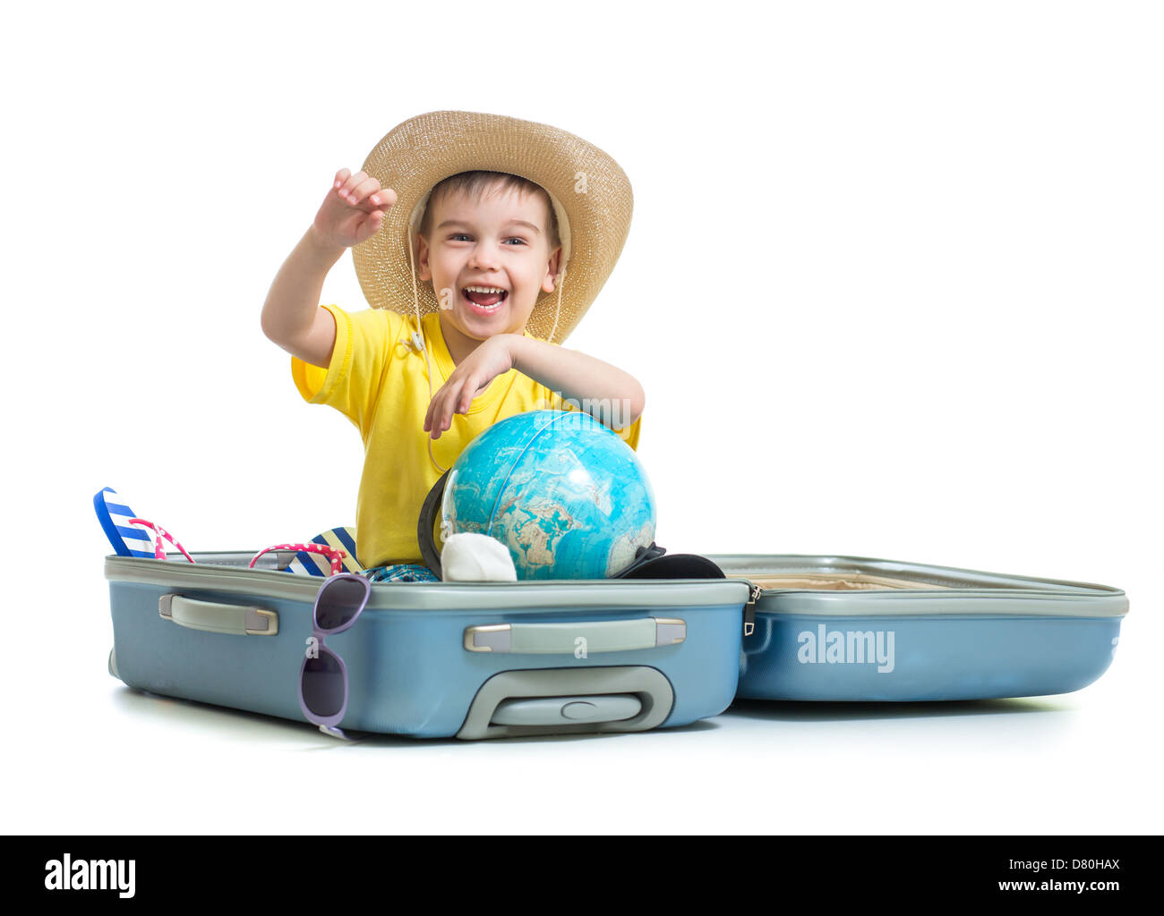 Happy kid sitting in suitcase prepared for vacation Stock Photo