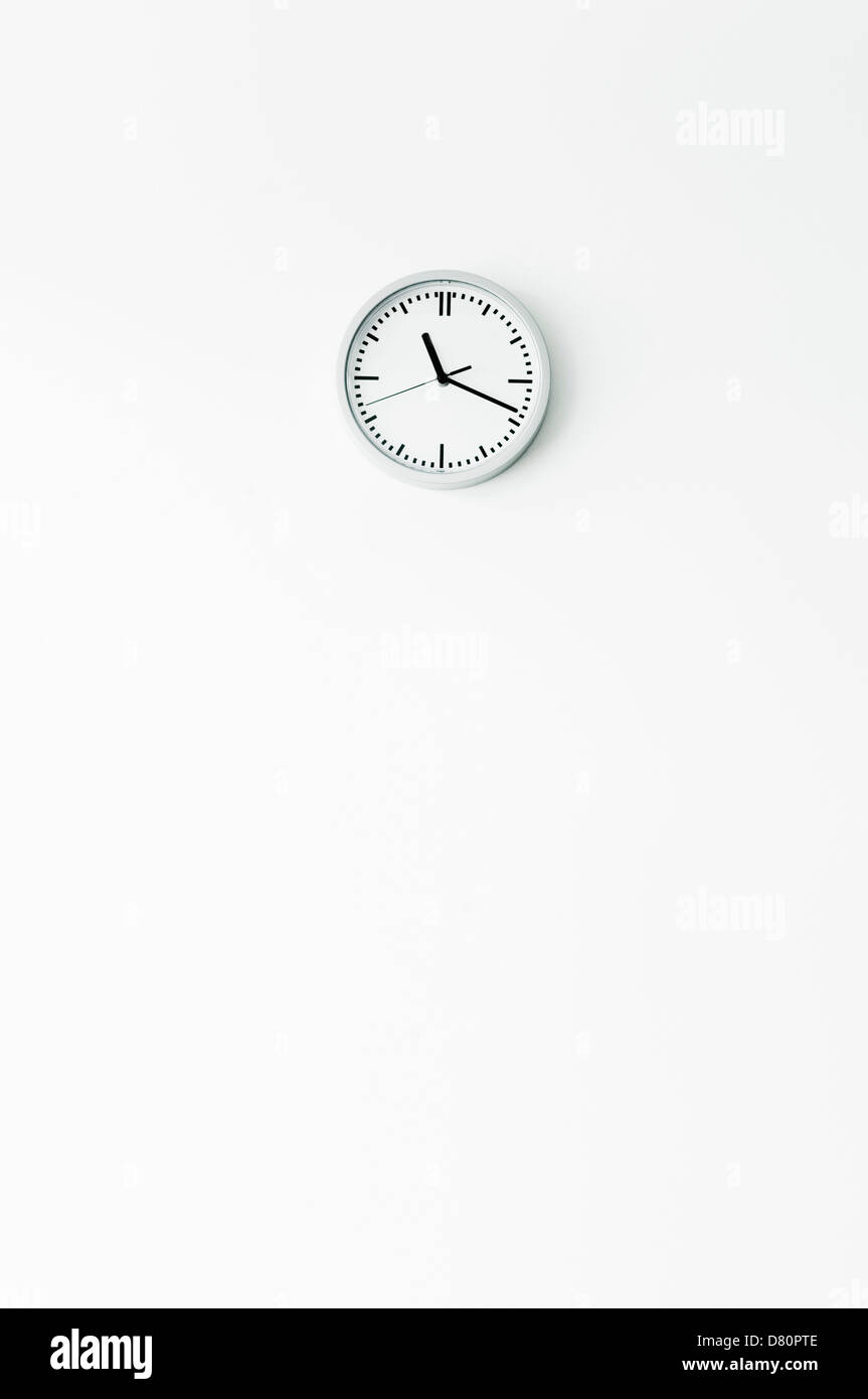 Clock on white wall Stock Photo Alamy