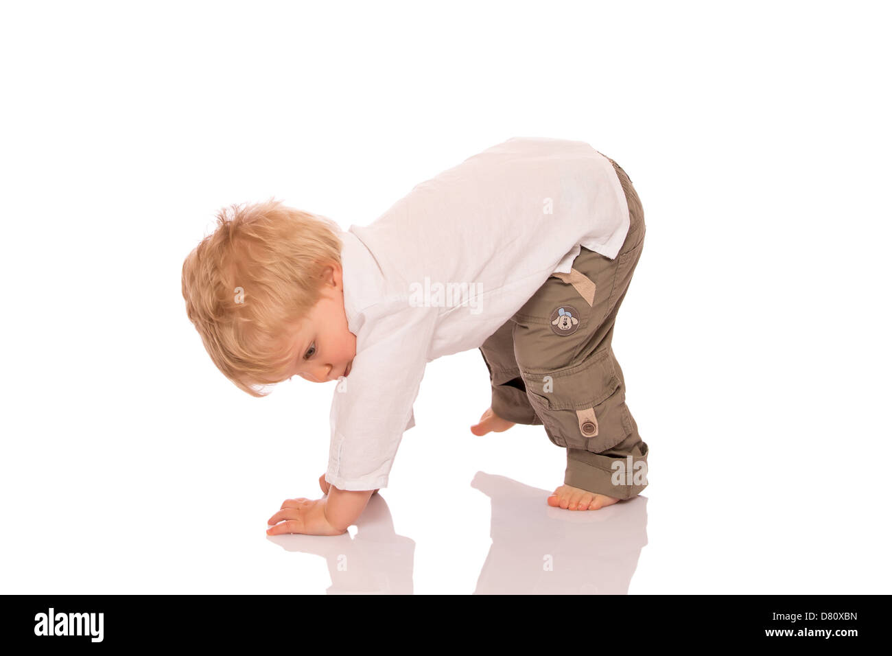 Young boy learning to walk. Isolated on white background Stock Photo