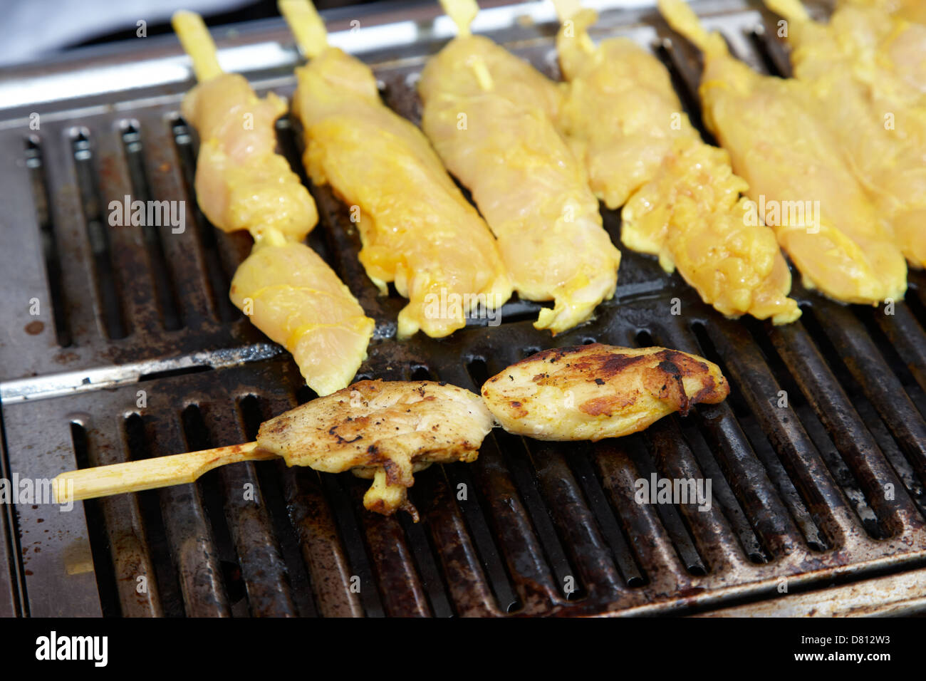 cooking chicken satay kebabs on a hot grill Stock Photo