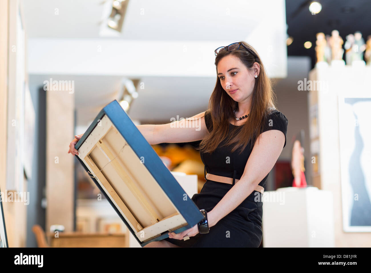 Caucasian woman examining painting in art gallery Stock Photo