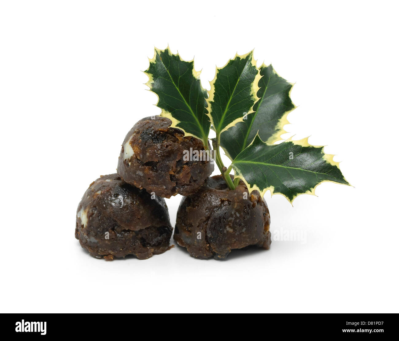 mini christmas puddings with a sprig of holly cut out onto a white background Stock Photo