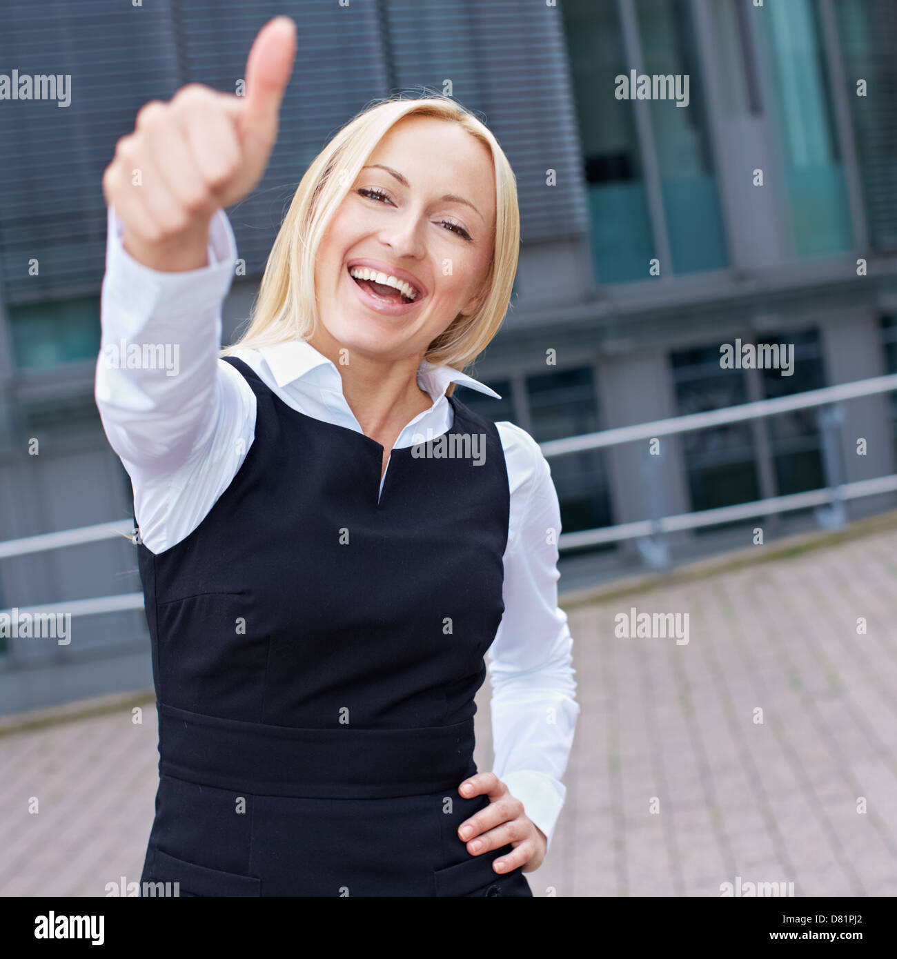 Cheering happy business woman holding her thumbs up Stock Photo