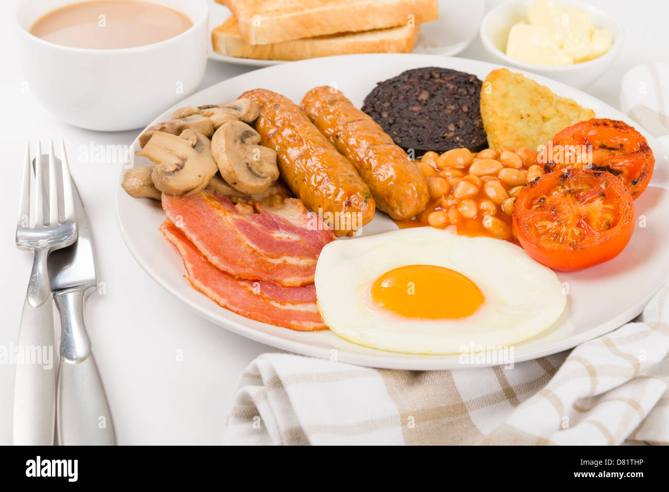 Full English Breakfast -  Fry-up with egg, bacon, mushrooms, tomatoes, sausages, black pudding, hash browns and baked beans. Stock Photo