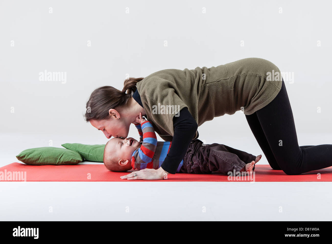 mother kissing baby during yoga Stock Photo