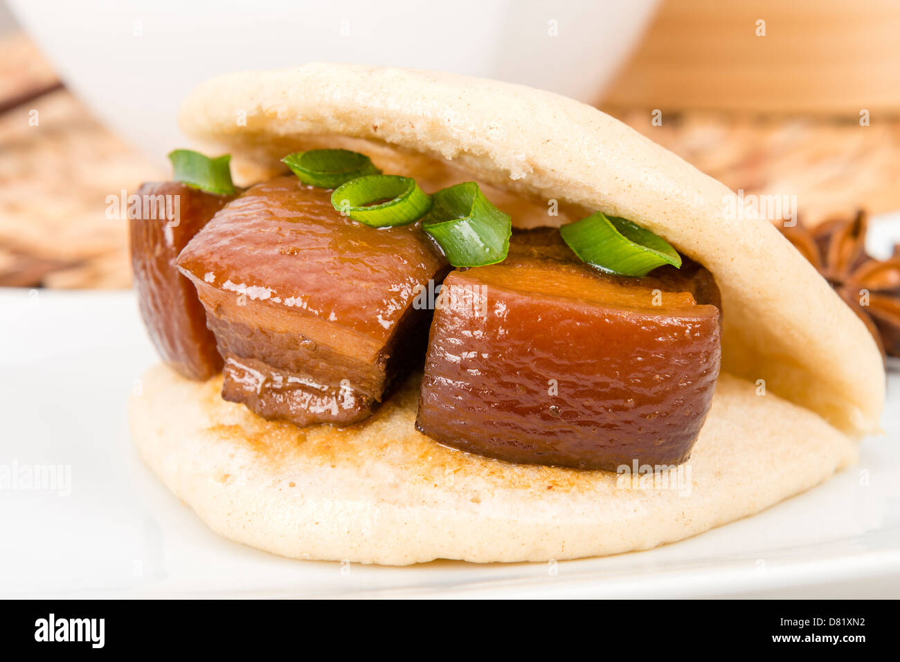 Hong Shao Rou - Pork belly caramelized and braised in soy sauce with star anise, cinnamon and chilies inside a steamed bun. Stock Photo