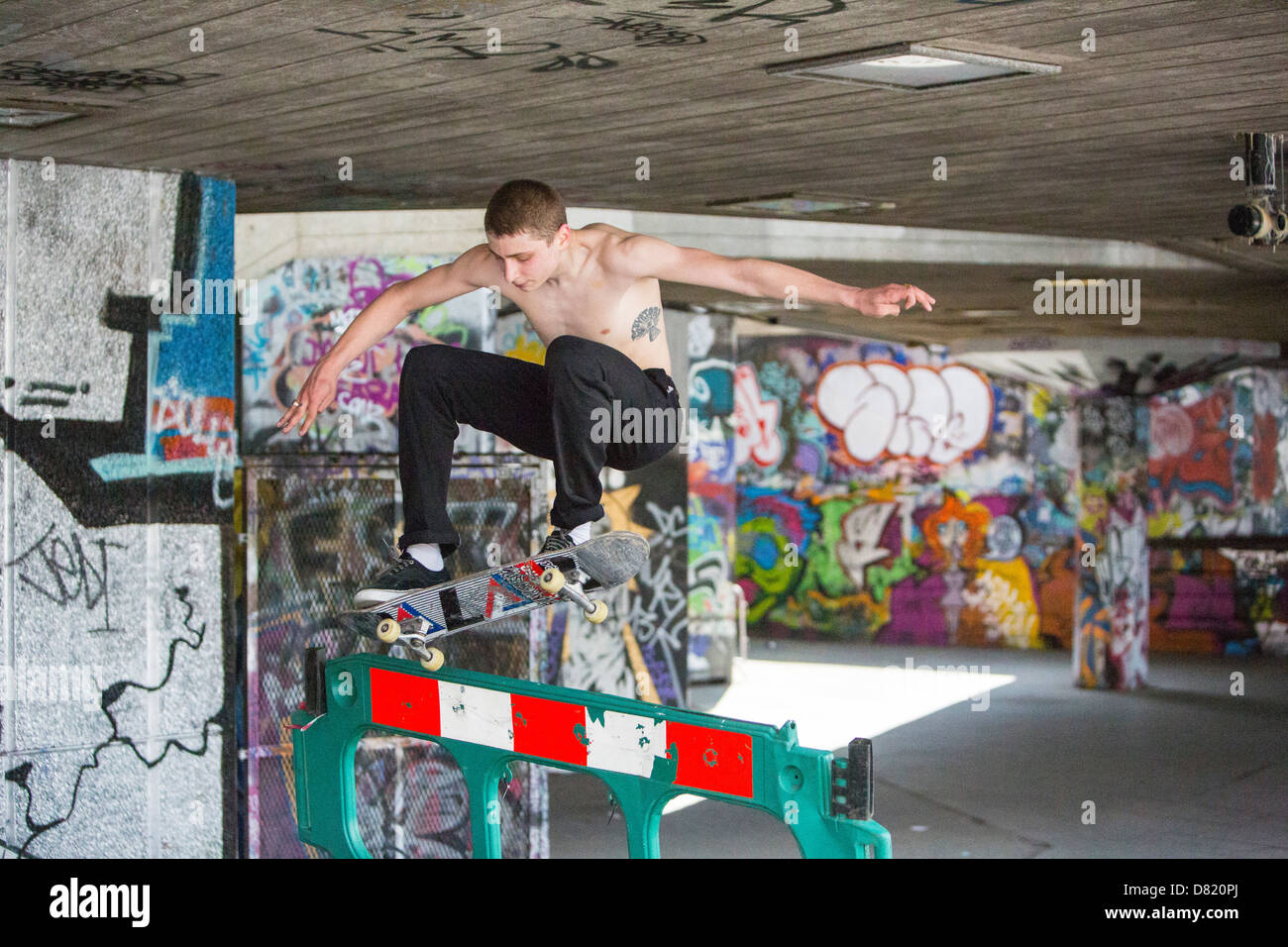 Skateboarders leaping obstacles on London's south Bank. Stock Photo