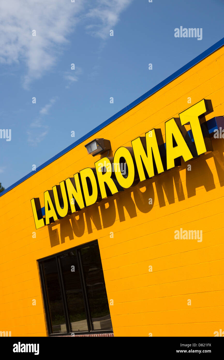 Yellow Laundromat Sign on Brightly Gold Painted Facade, USA Stock Photo