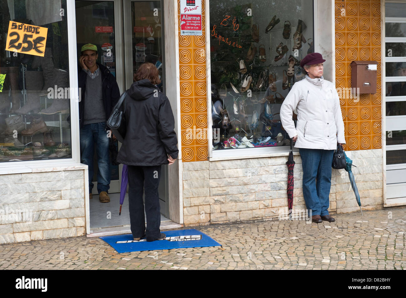 People at the shop entrance Easter Sunday in São Brás de Alportel Algarve Portugal Mediterranean Europe Stock Photo