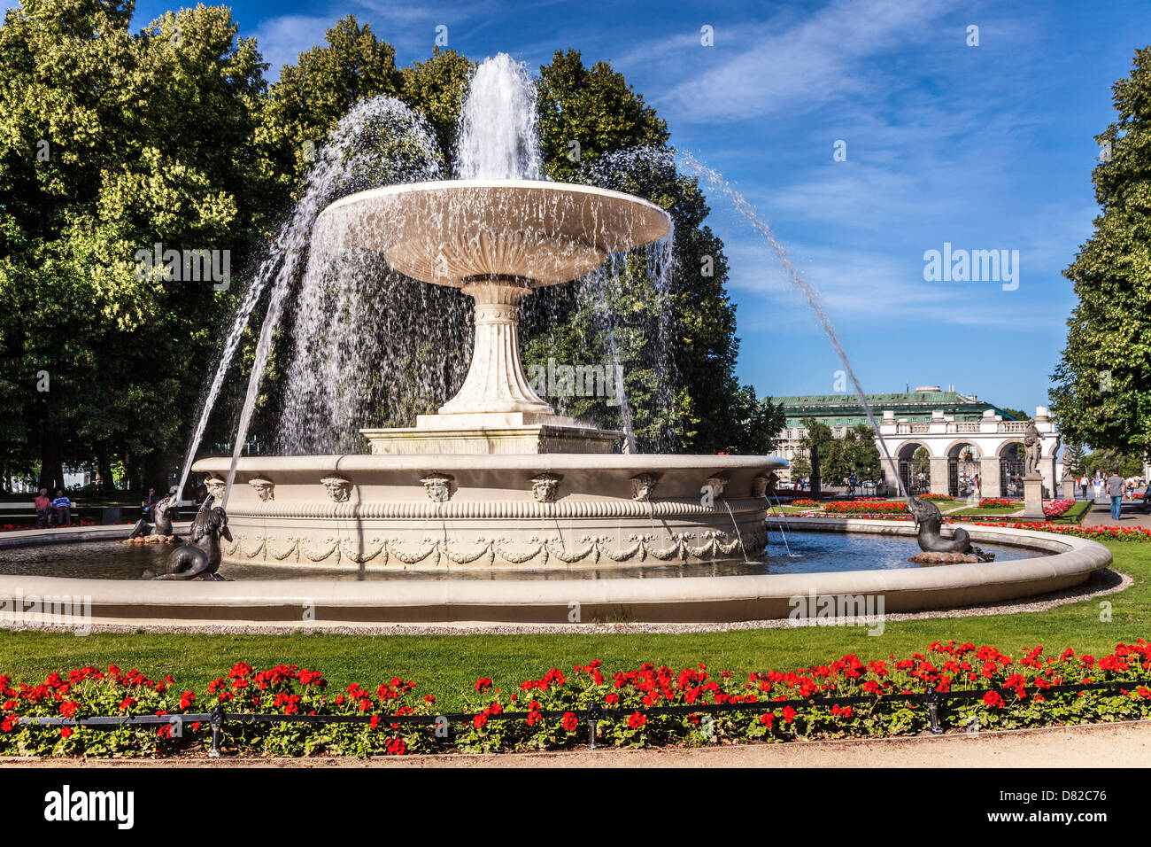 Fountain in Ogród Saski, Saxon Garden, oldest park in Warsaw with the Tomb of the Unknown Soldier in Pilsudski Square beyond. Stock Photo